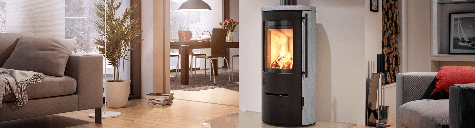 Kaminofen mit Speicherfunktion in hellem Wohnraum, schwarze Tür mit sichtbarem Feuer, graue Speichermasse, integrierte