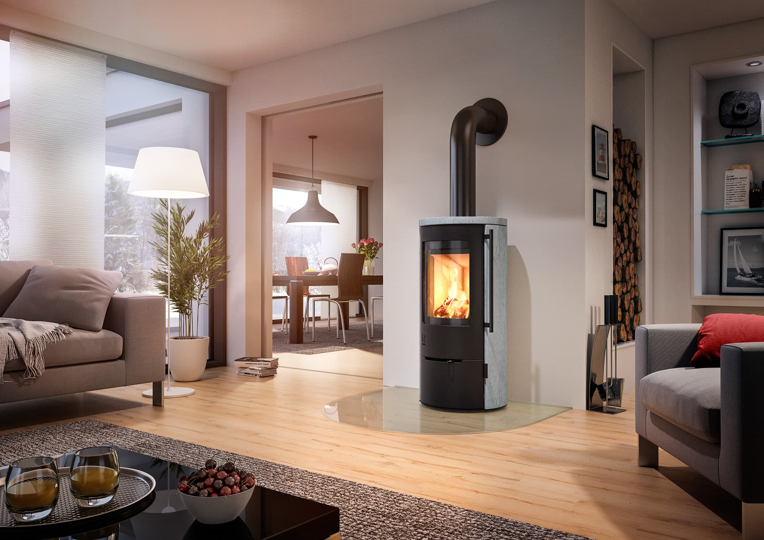 Speicherkaminofen Aprica 2 mit schwarzem Korpus und grauer Natursteinverkleidung in modernem Wohnzimmer, brennendes Feuer