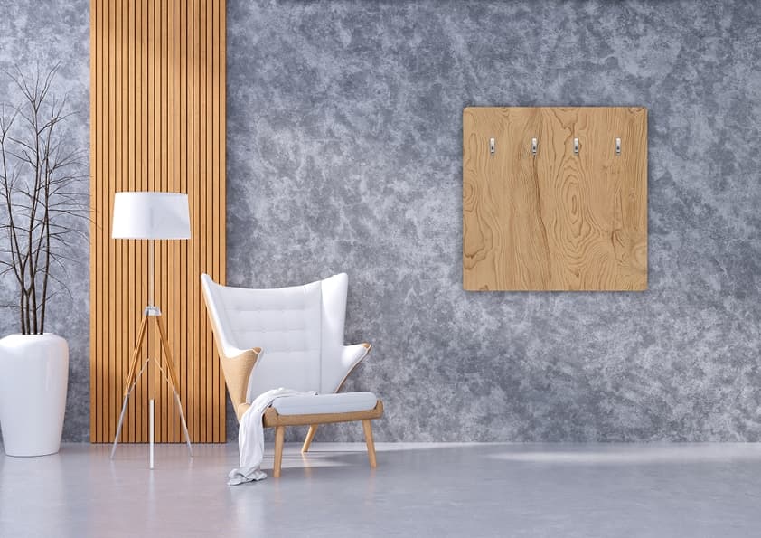 Ausstellungsraum mit Holzverkleidung, grauer Betonwand, weißem Sessel und Holzpaneelen als Wanddekoration
