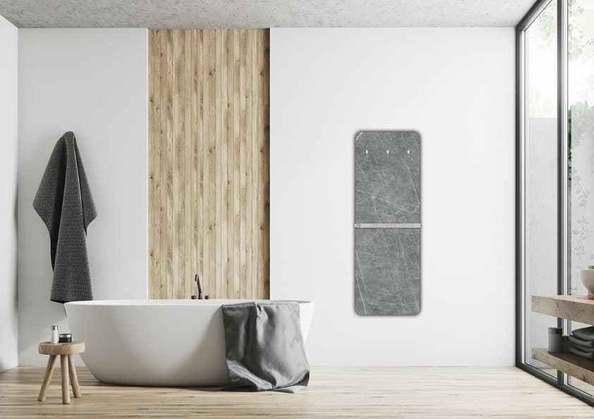 Moderner Speicherofen aus grauem Naturstein mit horizontaler Metalleinfassung an weißer Wand neben freistehender Badewanne