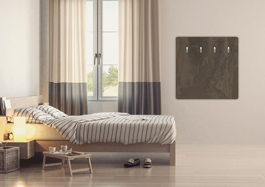 Moderner Kaminofen aus dunklem Naturstein an der Wand eines minimalistisch eingerichteten Schlafzimmers mit Doppelbett