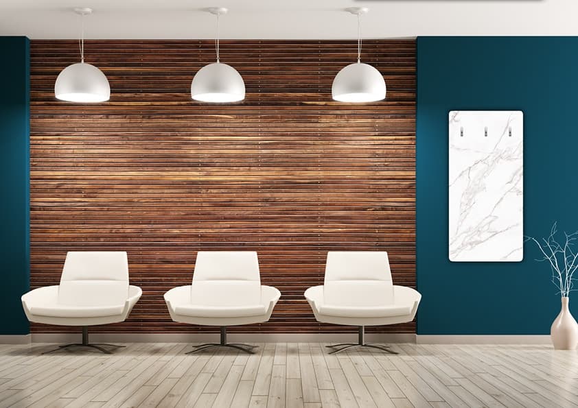 Modernes Wartezimmer mit drei weißen Designstühlen vor Holzwand, hängenden weißen Pendelleuchten und Teal-Wänden