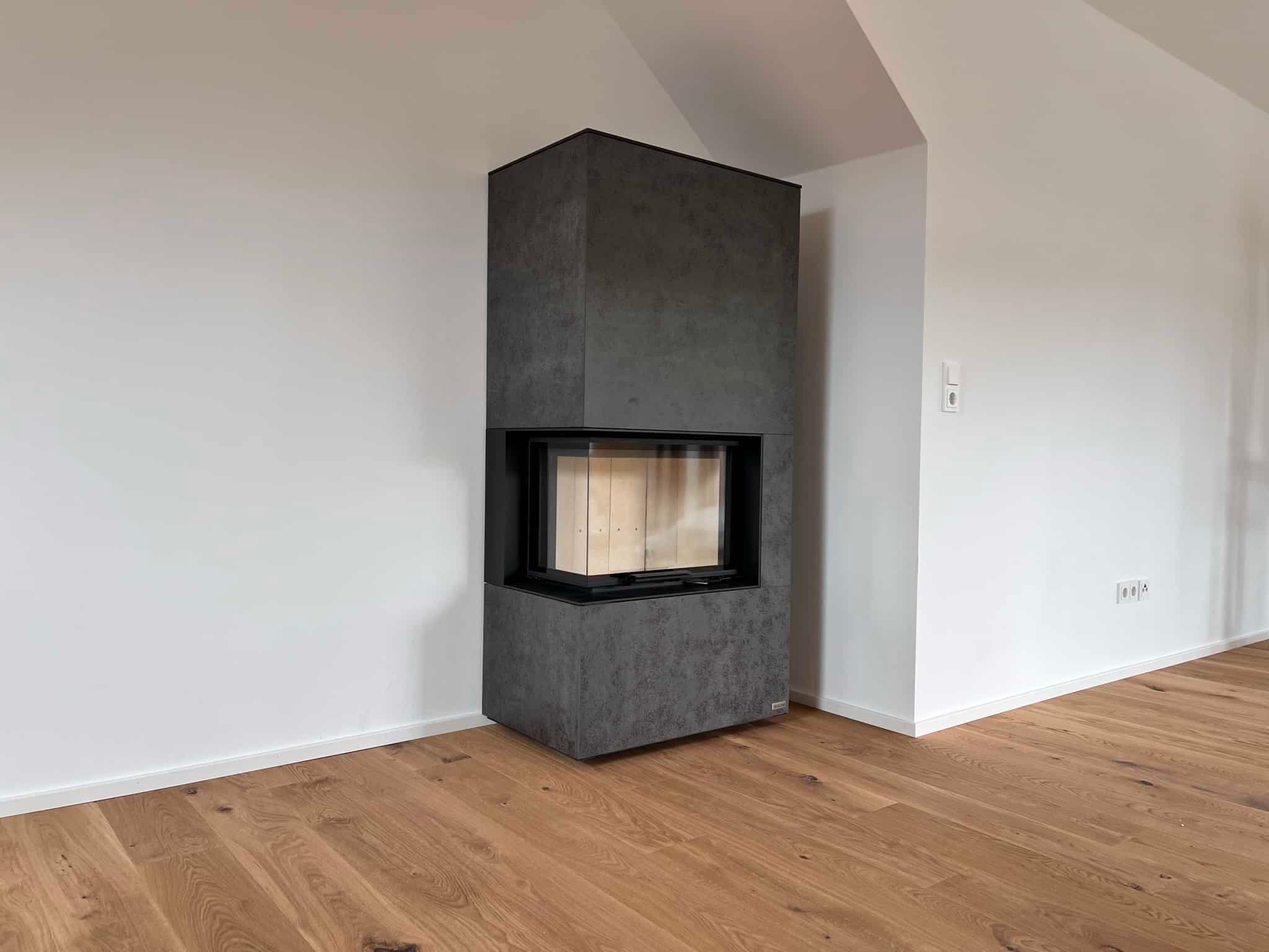 Kaminofen Neocube C20 mit Betonoptik und schwarzem Kaminrahmen in modernem Wohnraum