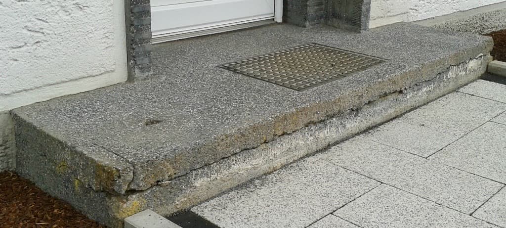 Rissiges Betonpodest vor der Treppensanierung in Mainfranken – beschädigte Außentreppe mit Abplatzungen
