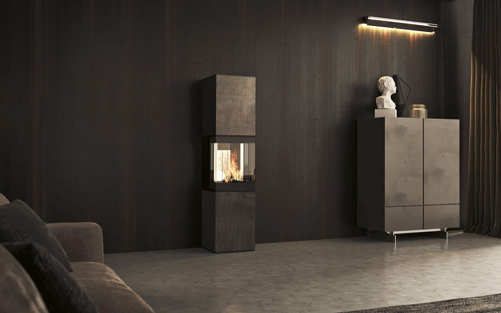 neocube S30XL steel edition: schmaler hoher Kaminofen in Rohstahl vor einer dunklen Holzwand, daneben ein Sideboard.