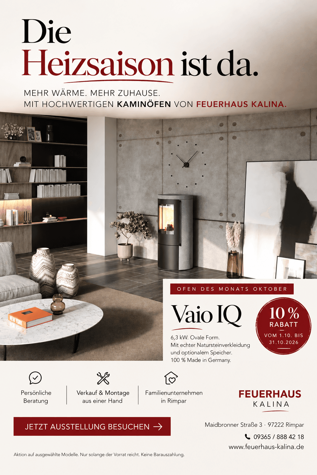 Ofen des Monats Oktober 2026: CB-tec Vaio IQ, ovaler Kaminofen mit Natursteinverkleidung und brennendem Feuer in einem modernen Wohnraum mit Betonwand, Bücherregal und heller Sitzecke — 10 Prozent Rabatt vom 1.10. bis 31.10.2026 bei Feuerhaus Kalina in Rimpar bei Würzburg.